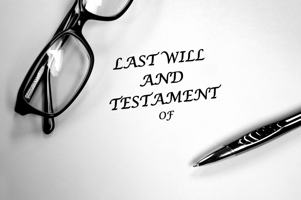 A Last Will and Testament with a pair of glasses and a black pen sitting on top of it.